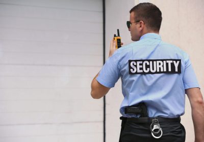 Male security guard with portable radio outdoors